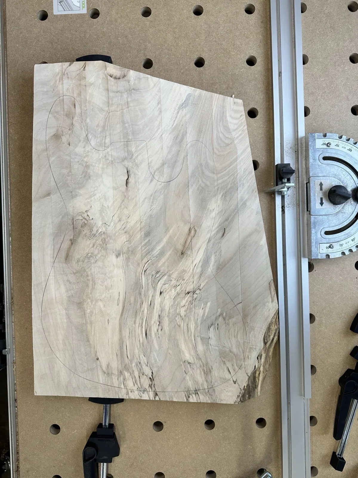 Guitar body blank roughed out on a workbench