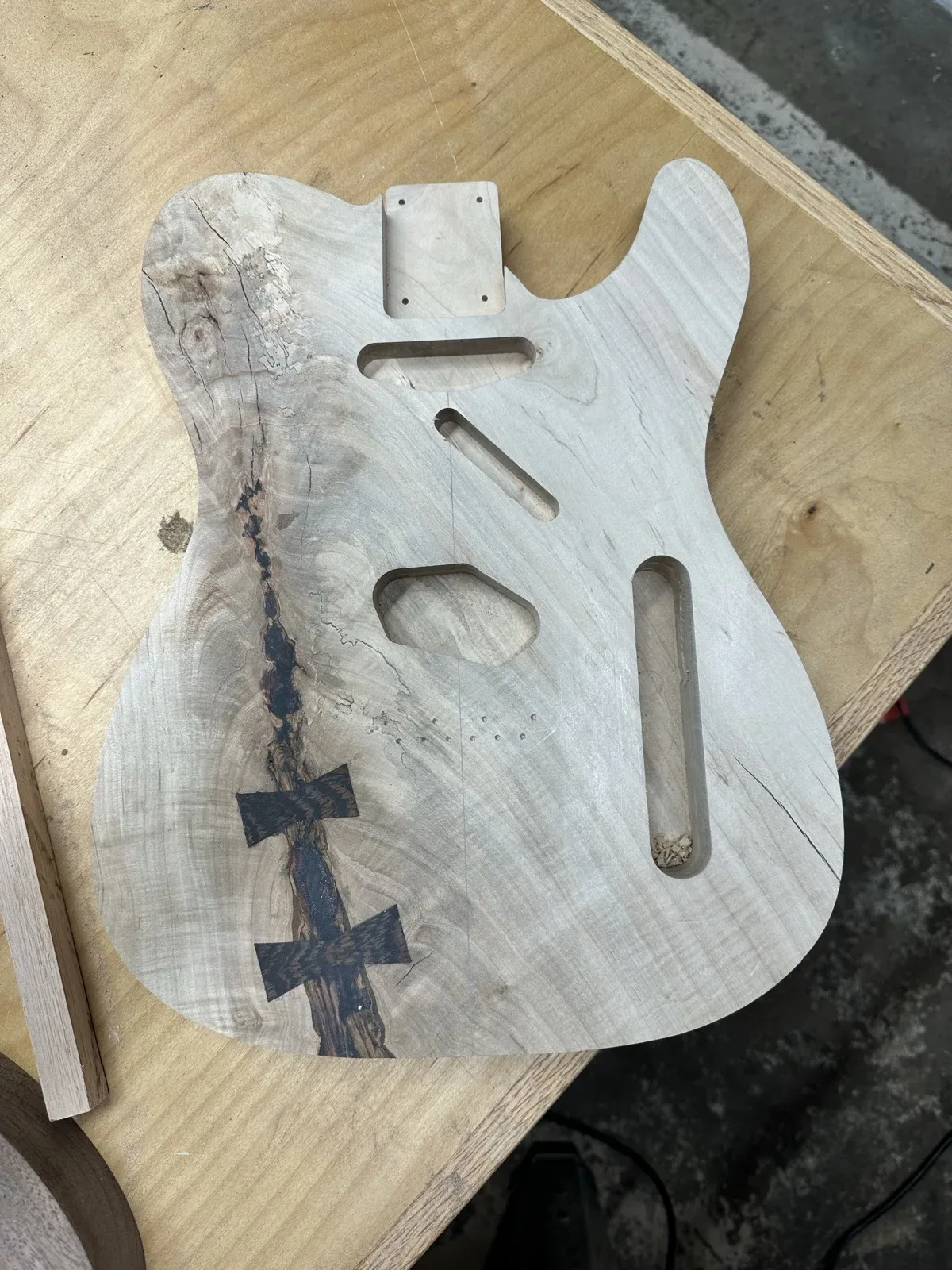 Guitar body with butterfly key inlays repairing a crack