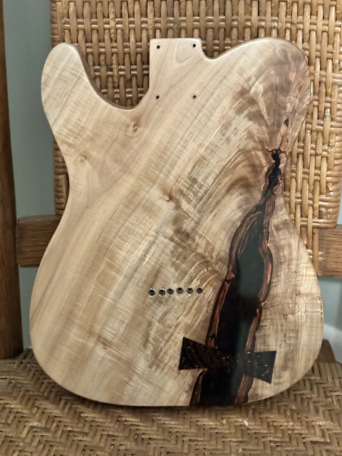 Back of a guitar body with a butterfly key inlay and crack