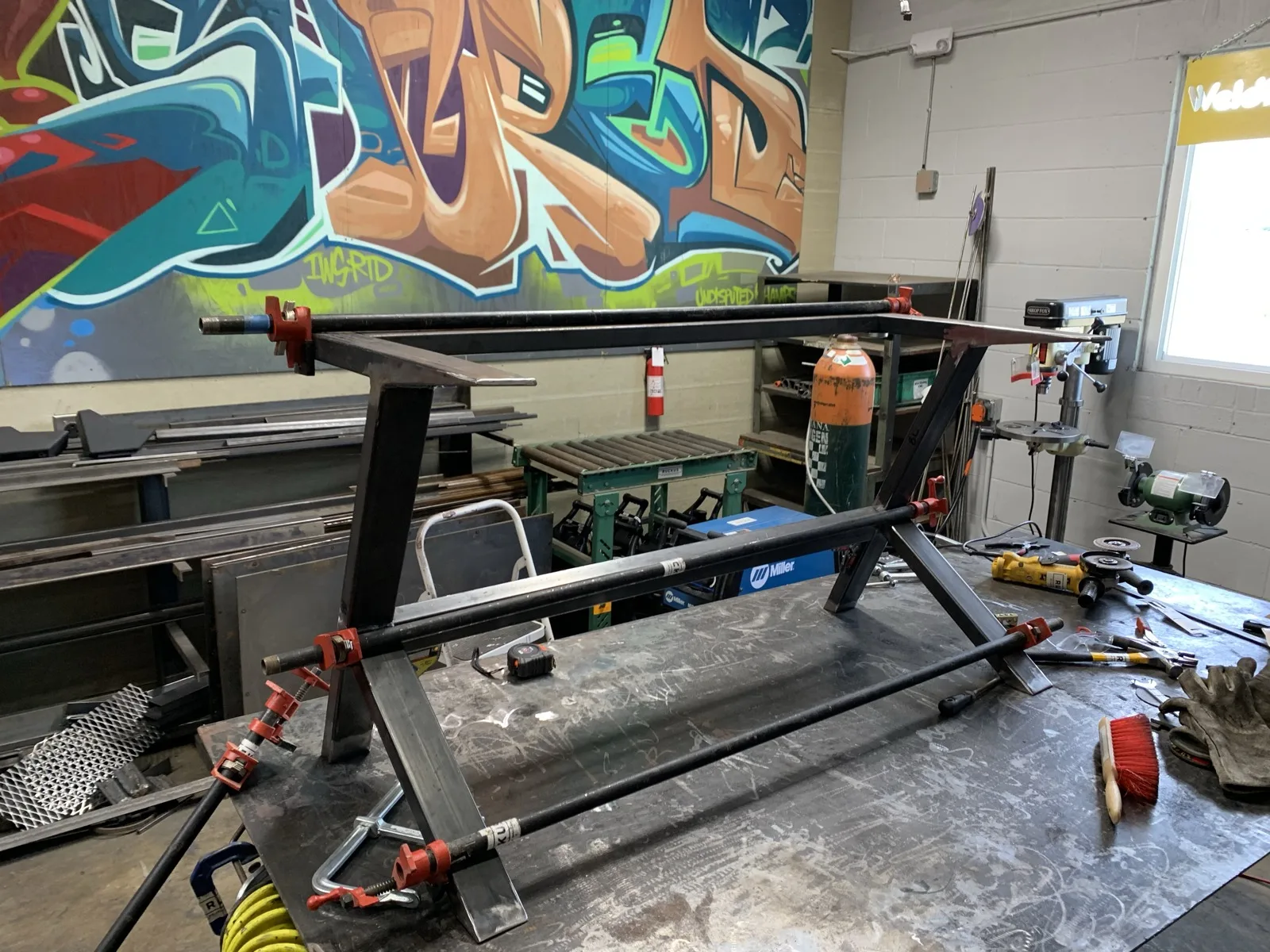 Welded steel table frame clamped together in a garage