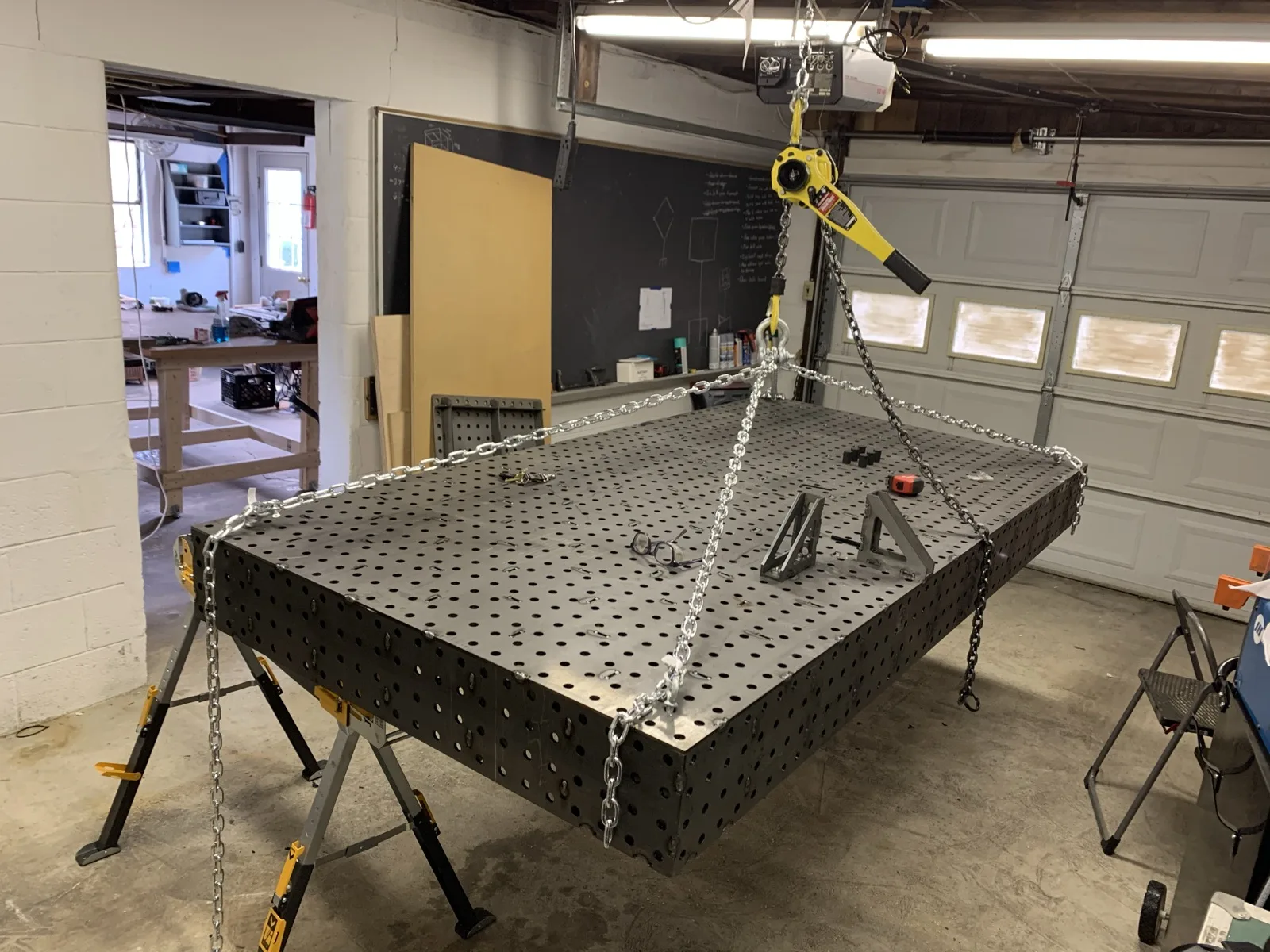 Welding table top being lifted by a chain hoist
