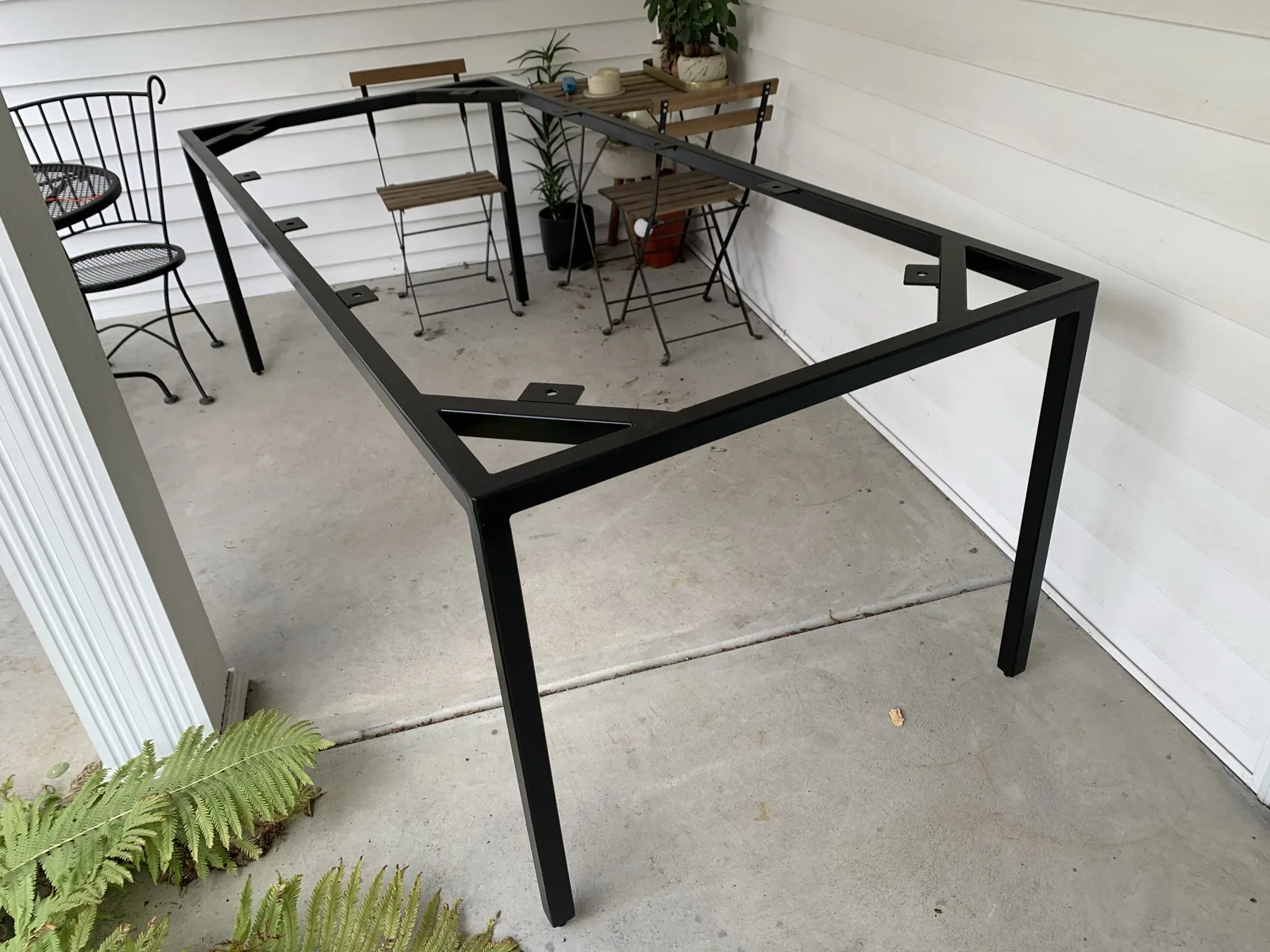 Finished black steel table frame on a porch