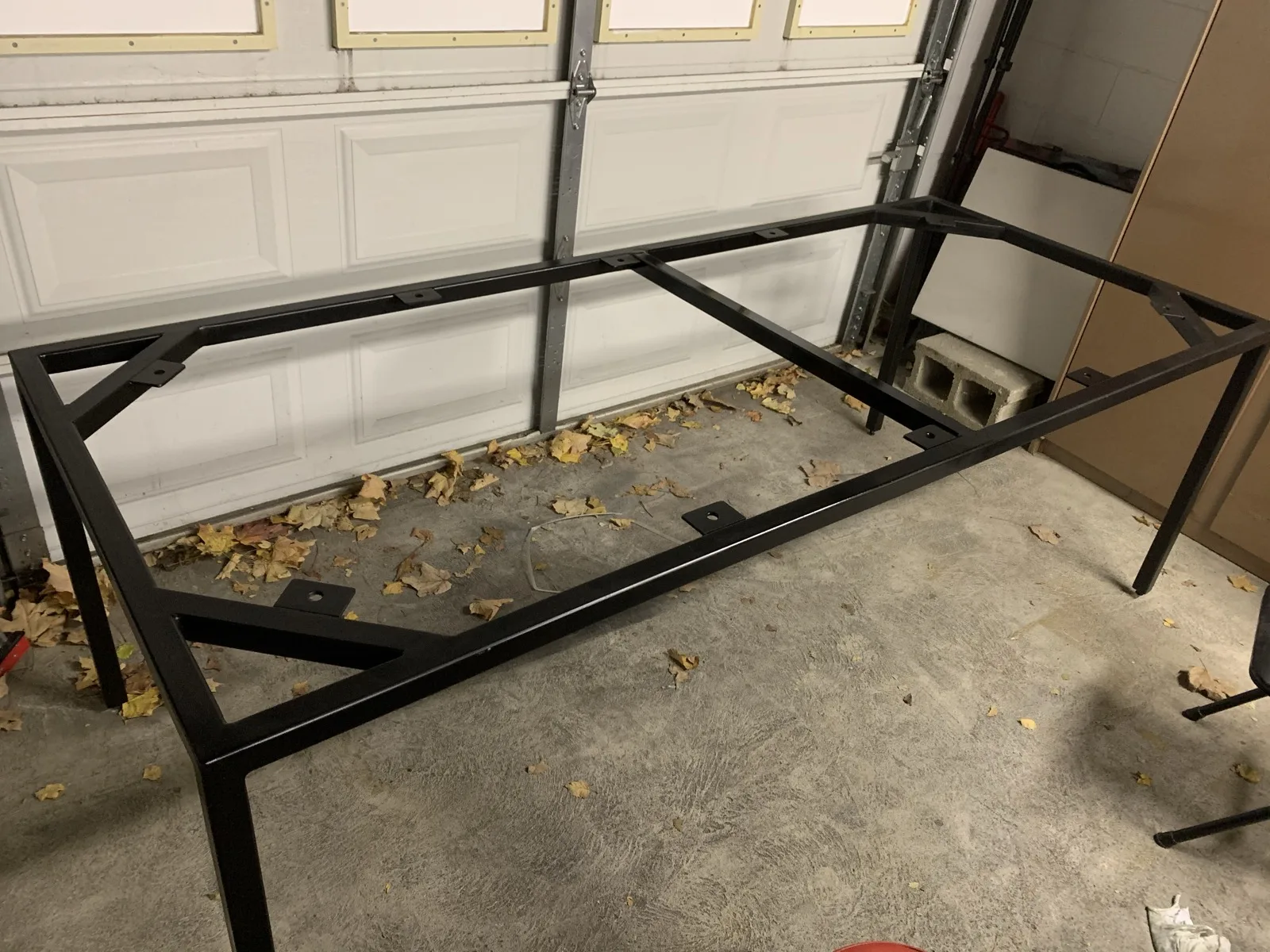 Finished black steel table frame in a garage