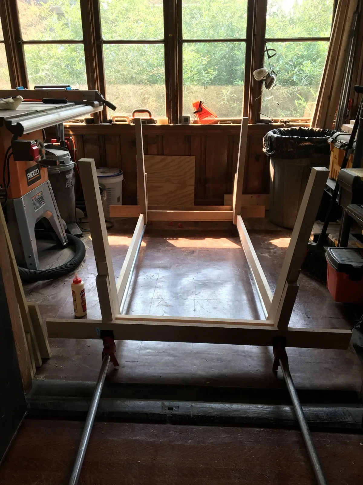 Table frame joinery clamped together in a garage