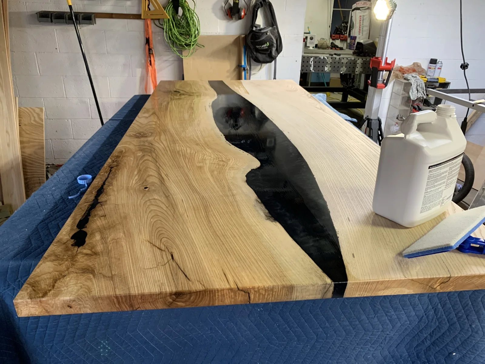 Close-up of an epoxy river table top with black resin inlay